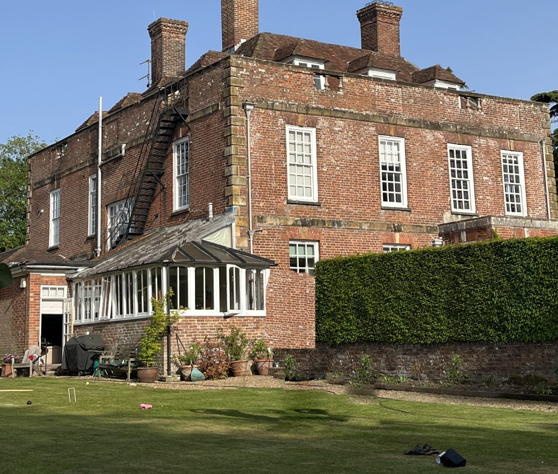 Westwell House, a red-brick house with a big lawn