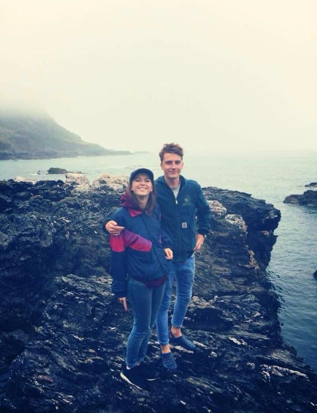 Jojo and Louis standing on rocks by the sea